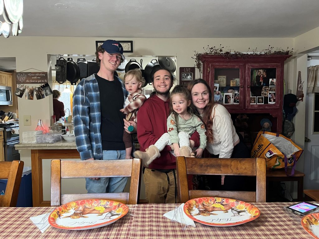 Logan and family gathered in the dining room on Thanksgiving, some time after being reunited with help from The Home's Youth Permanency Connections program