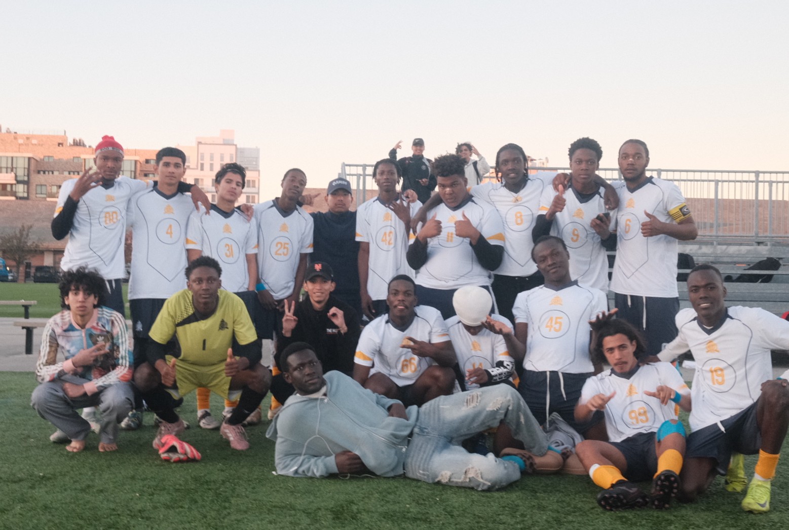 Roberto Quezada poses with Queens Satellite High School soccer team