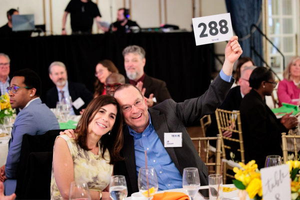 Attendees raise their bid number