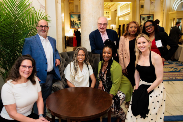 Supporters and staff sit around a table at The Home's Voices & Visions